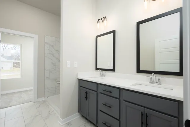 a bathroom with double sink and a mirror