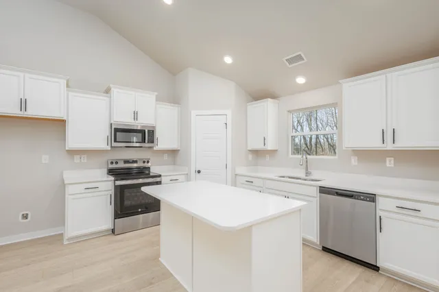 a kitchen with stainless steel appliances sink stove top oven and cabinets