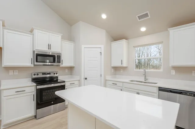 a kitchen with a sink a stove and microwave