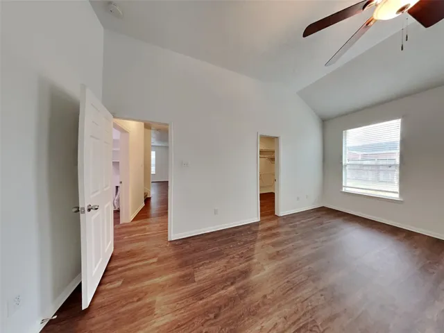 an empty room with wooden floor and a window