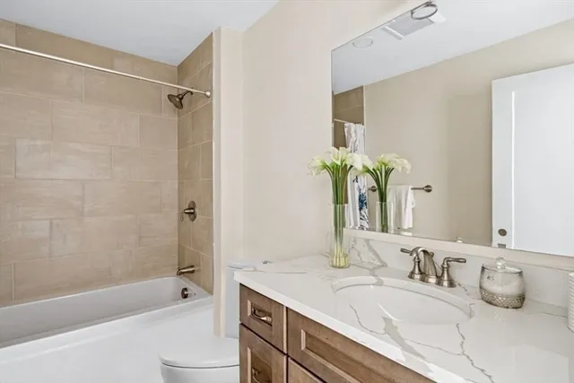 a bathroom with a granite countertop tub sink and mirror