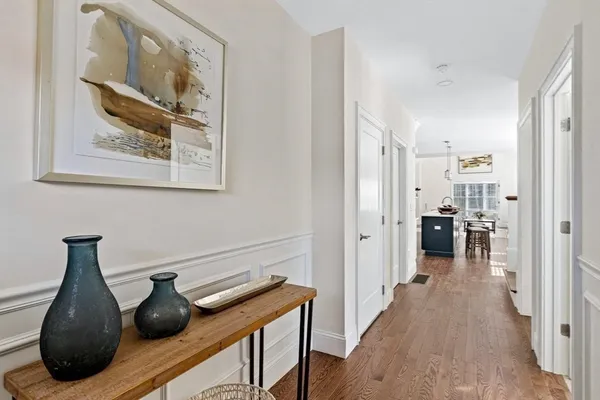 a view of a hallway with furniture and wooden floor