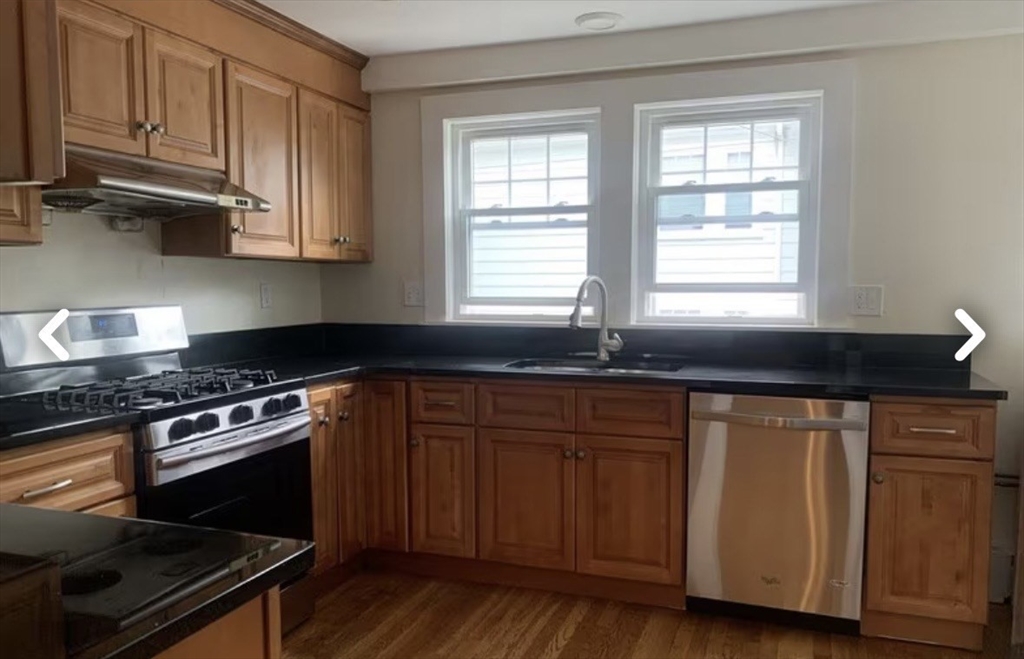 55 Elgin Street, Unit 55 Newton, MA 02459 - Photo 1 of 8 a kitchen with granite countertop wooden cabinets and a stove top oven