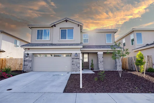 a front view of a house with a yard and garage