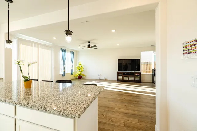 a view of a dining room and livingroom with furniture wooden floor a chandelier