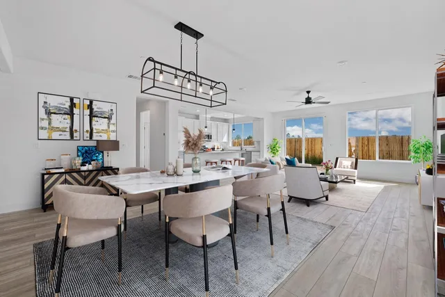 a view of a dining room and livingroom with furniture wooden floor a chandelier