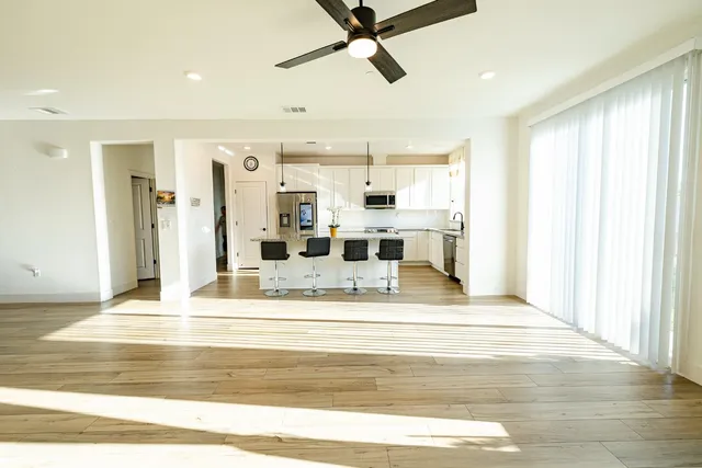 a kitchen with stainless steel appliances granite countertop a refrigerator a oven a sink dishwasher and white cabinets with wooden floor