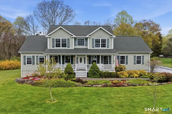 a front view of a house with a yard and trees