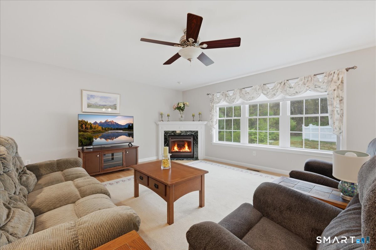 3 Lucienne Way Ledyard, CT 06339 - Photo 16 of 25 a living room with furniture a fireplace and a flat screen tv