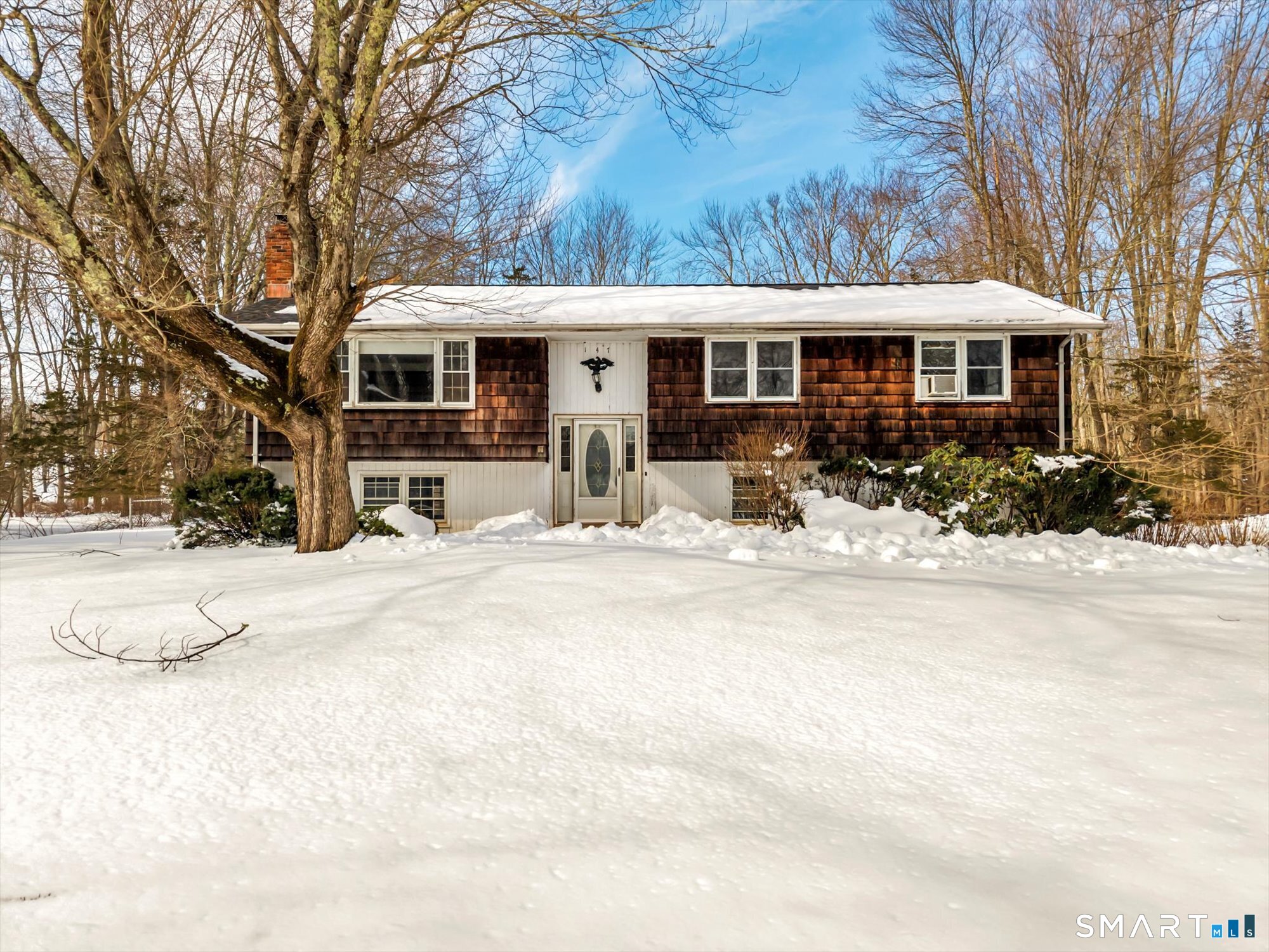 a front view of a house with yard covered in snow