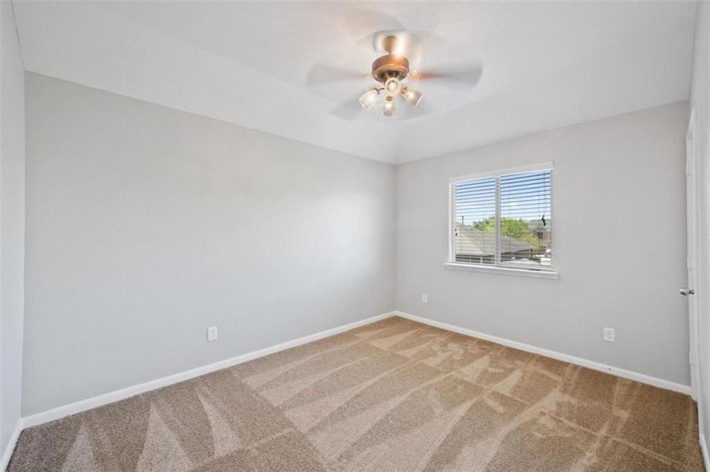 22438 Toronado Ridge Lane Porter, TX 77365 - Photo 15 of 19 Bright and airy bedroom featuring soft carpet, neutral walls, a ceiling fan, and a window that invites natural light.
