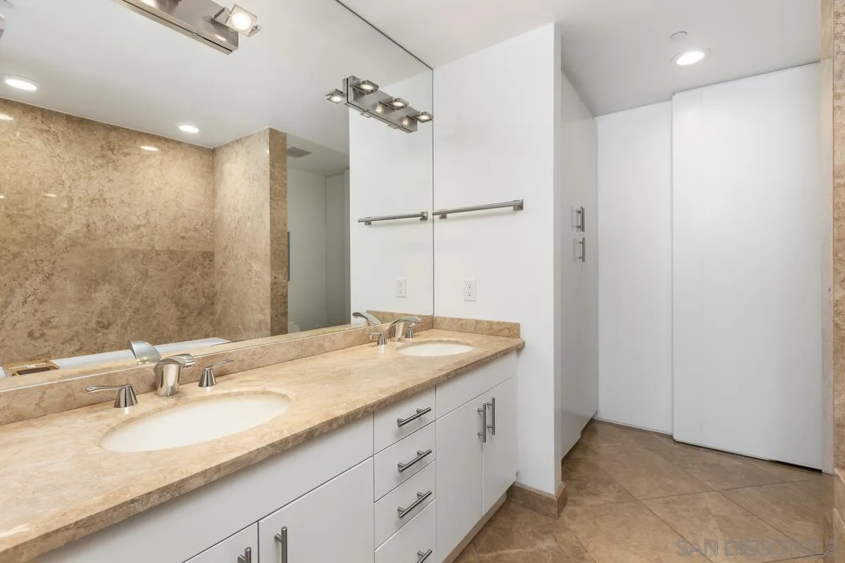 645 Front Street, Unit 2004 San Diego, CA 92101 - Photo 32 of 47 a bathroom with a granite countertop sink and a mirror