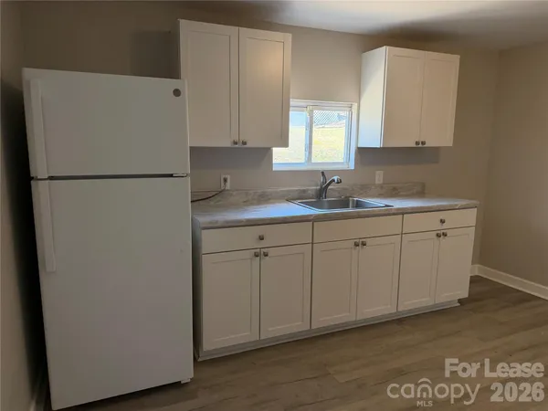 a kitchen with a sink a refrigerator and cabinets