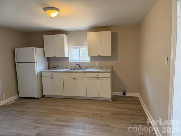 a view of a kitchen with wooden floor and cabinets