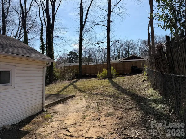 a view of a house with snow on the road and covered with trees