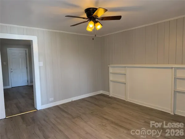 a view of an empty room with wooden floor