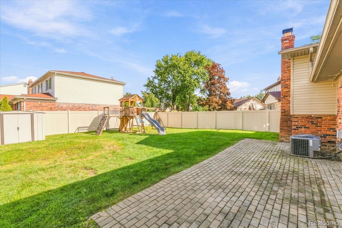 6767 Longwood Road Canton, MI 48187 - Photo 39 of 59 Expansive backyard featuring a paver patio, brick exterior, and a privacy fence