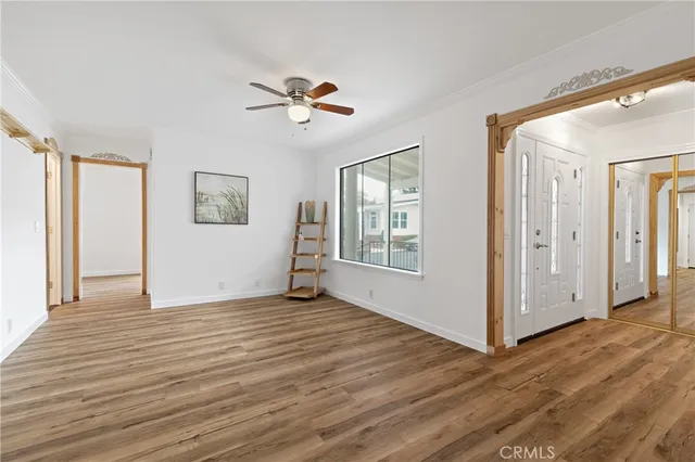a view of an empty room with window and wooden floor