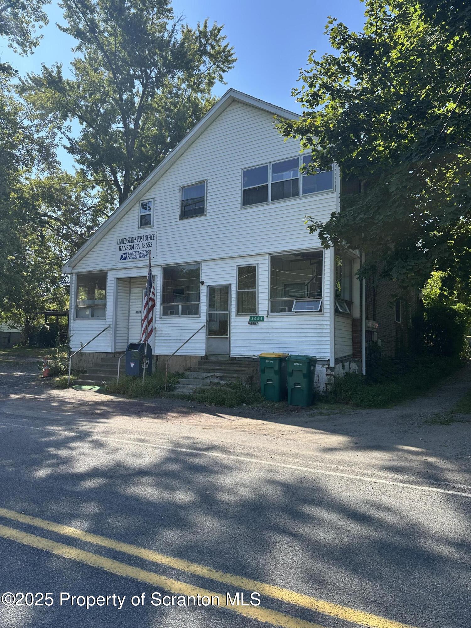 3061-3065 Main Street Clarks Summit, PA 18411 - Photo 3 of 34 a front view of a house with a yard and trees