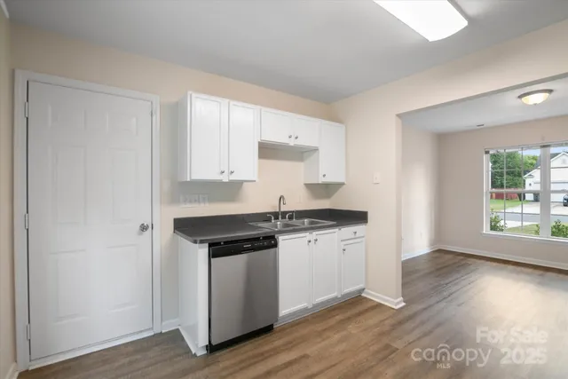a kitchen with stainless steel appliances granite countertop a stove and a white cabinets