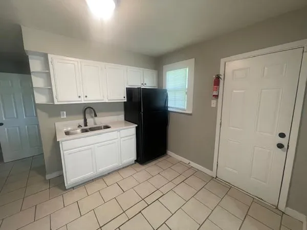 a kitchen with a refrigerator sink and cabinets