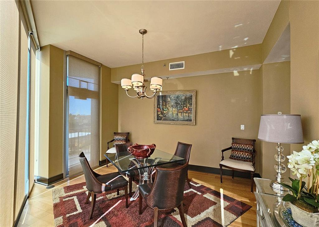 4561 Olde Perimeter Way, Unit 1202 Atlanta, GA 30346 - Photo 11 of 46 a view of a dining room with furniture and chandelier