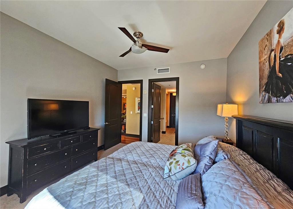 4561 Olde Perimeter Way, Unit 1202 Atlanta, GA 30346 - Photo 14 of 46 a bedroom with furniture and a flat screen tv