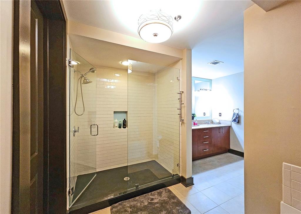 4561 Olde Perimeter Way, Unit 1202 Atlanta, GA 30346 - Photo 16 of 46 a bathroom with a shower and a sink