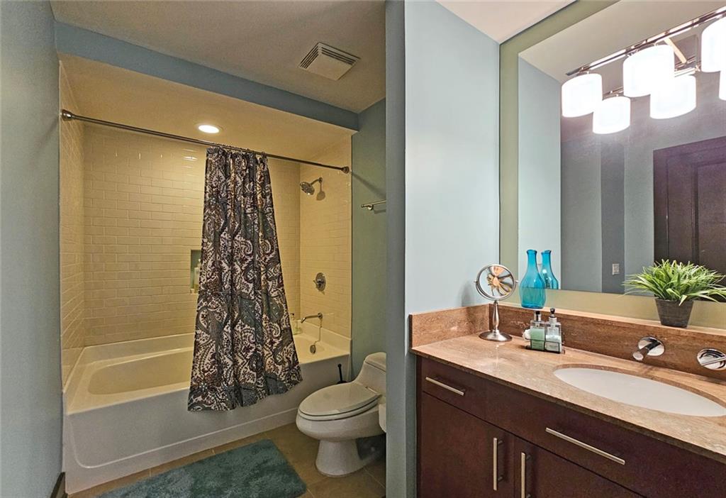 4561 Olde Perimeter Way, Unit 1202 Atlanta, GA 30346 - Photo 19 of 46 a bathroom with a granite countertop sink toilet and shower