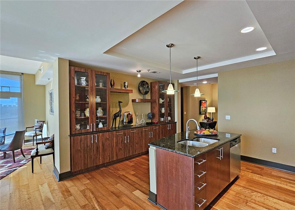 4561 Olde Perimeter Way, Unit 1202 Atlanta, GA 30346 - Photo 7 of 46 a kitchen with stainless steel appliances granite countertop a stove and a wooden floors