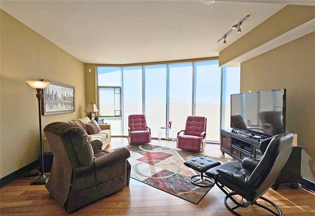 4561 Olde Perimeter Way, Unit 1202 Atlanta, GA 30346 - Photo 8 of 46 a living room with furniture a flat screen tv and a floor to ceiling window