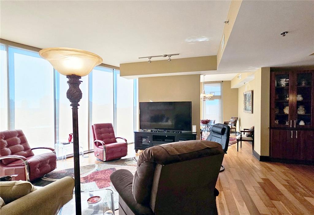 4561 Olde Perimeter Way, Unit 1202 Atlanta, GA 30346 - Photo 9 of 46 a living room with furniture and a flat screen tv