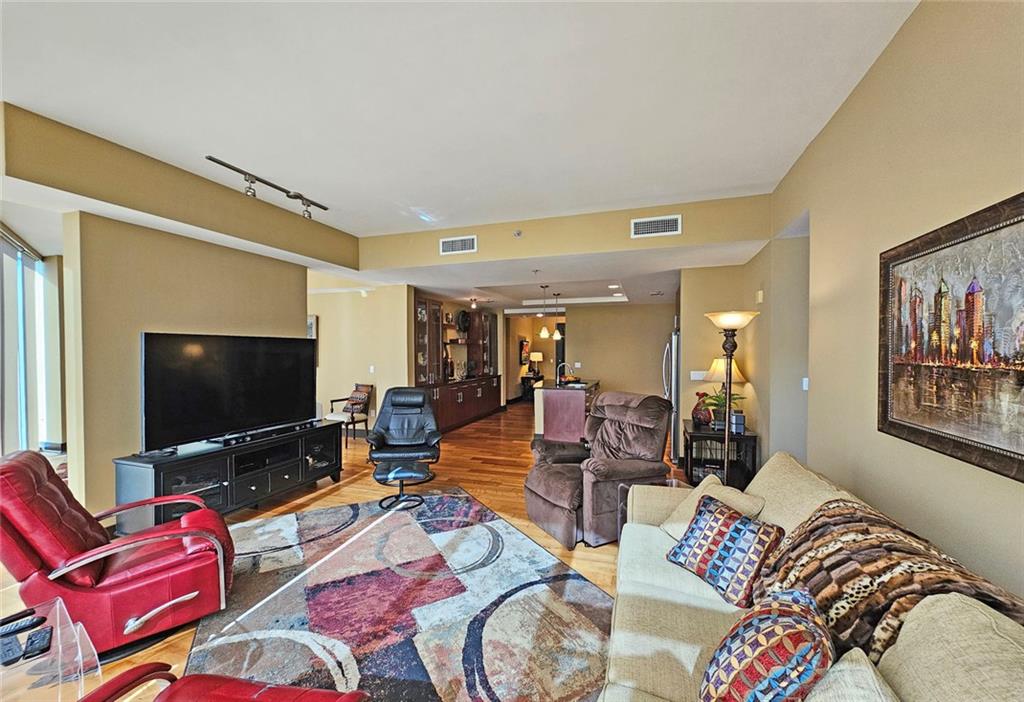 4561 Olde Perimeter Way, Unit 1202 Atlanta, GA 30346 - Photo 10 of 46 a living room with furniture and a flat screen tv