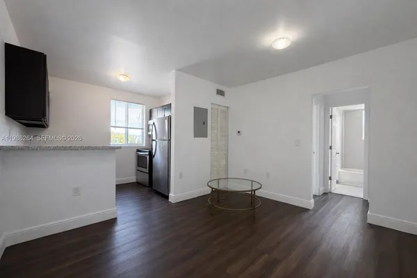 a view of a kitchen with wooden floor and a refrigerator