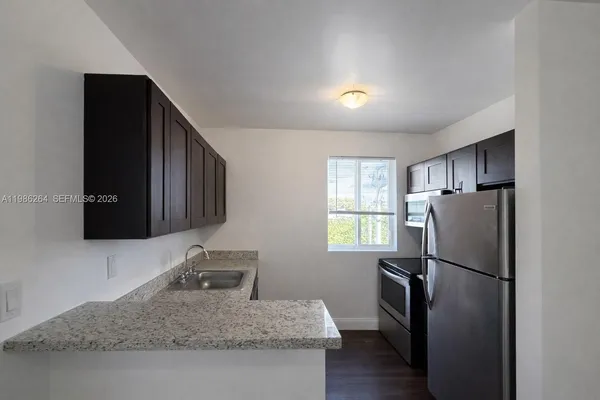 a kitchen with stainless steel appliances granite countertop a refrigerator and a stove top oven