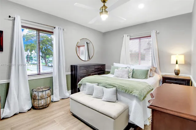 a bedroom with a bed a mirror and a window