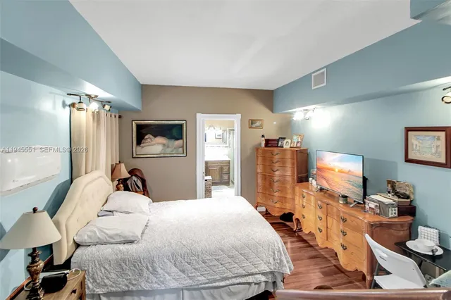 a bedroom with a bed and flat screen tv