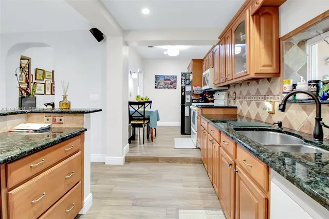 a kitchen with stainless steel appliances granite countertop a sink and cabinets