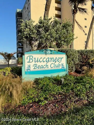 a living room with patio furniture and a floor to ceiling window