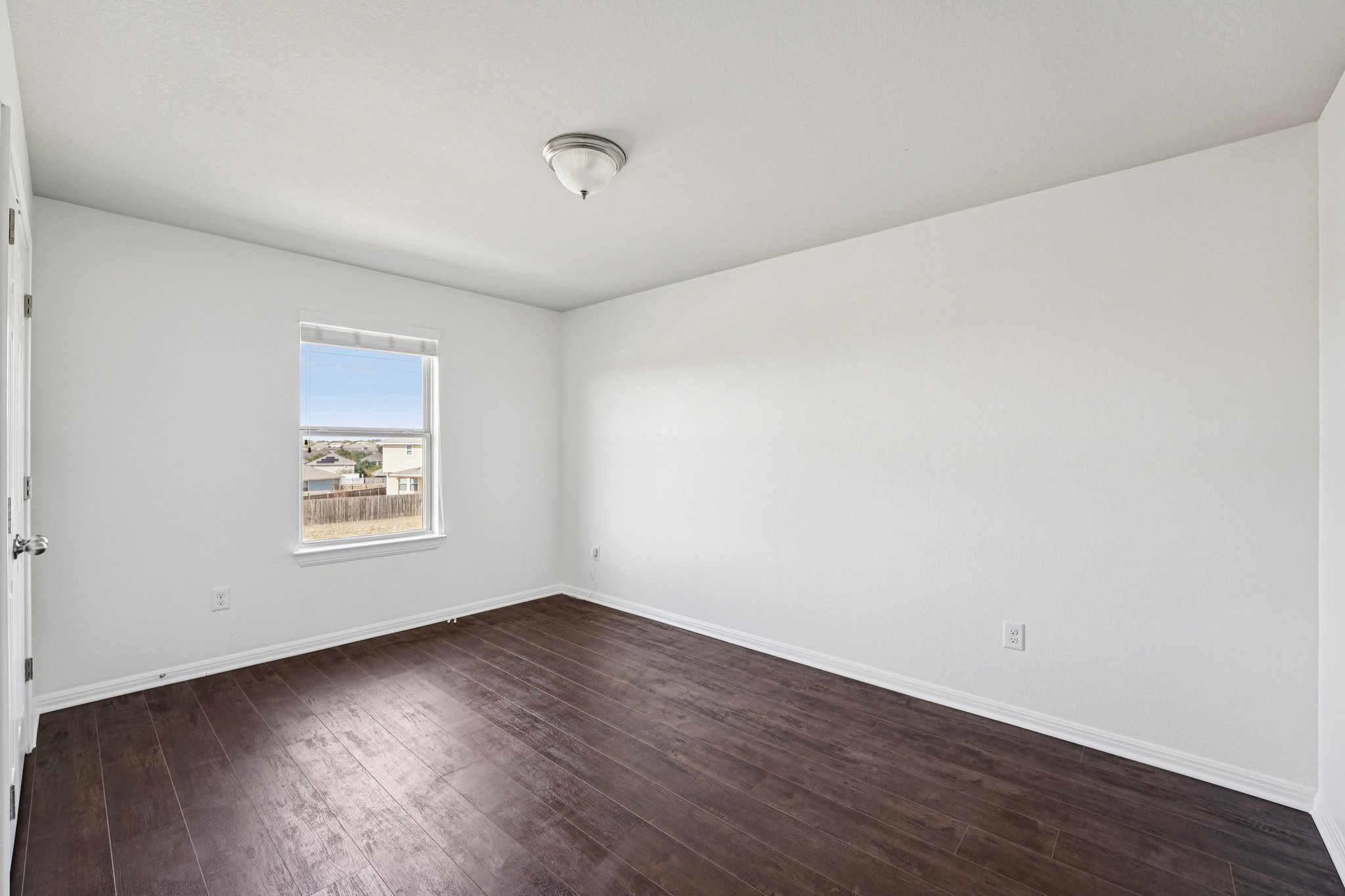 288 Triumph Road Buda, TX 78610 - Photo 12 of 19 an empty room with wooden floor and windows
