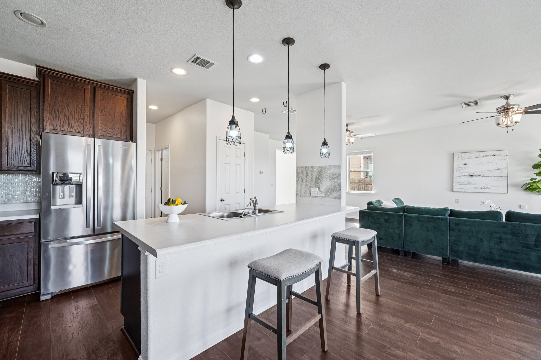 288 Triumph Road Buda, TX 78610 - Photo 7 of 19 a kitchen with stainless steel appliances granite countertop a refrigerator a sink a stove a dining table and chairs with wooden floor