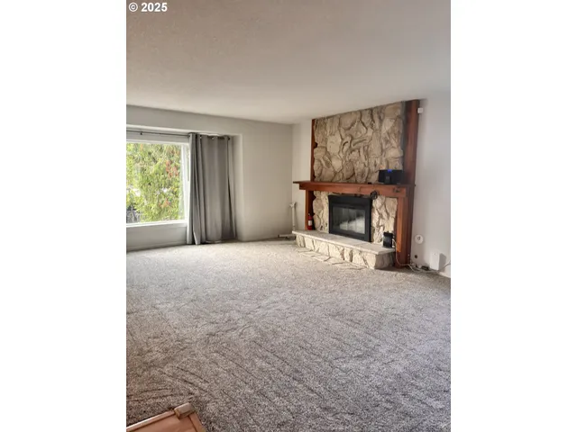 a view of an empty room with a fireplace