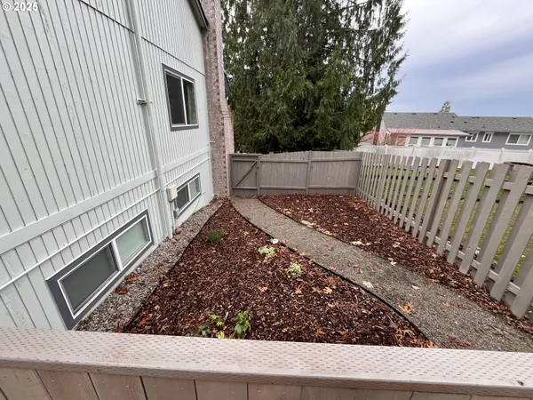 a view of a yard with wooden fence