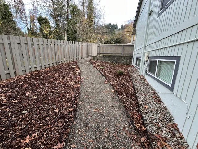 a view of a yard with wooden fence