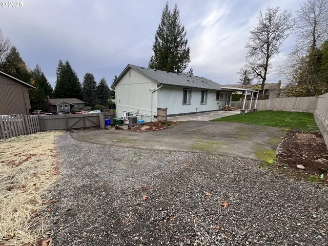a view of a house with a yard and parking space