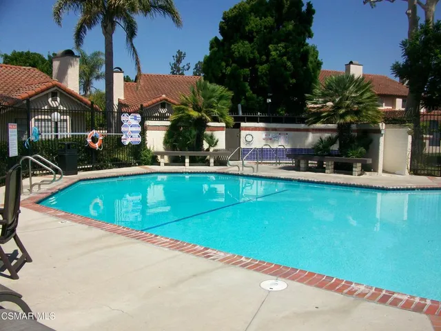 a view of a house with pool and chairs