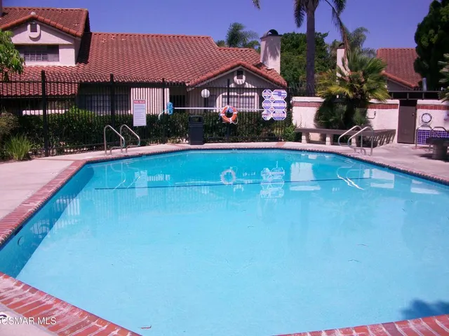 a front view of house and yard with swimming pool and outdoor seating