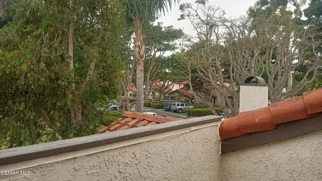 a view of a backyard with couches and table under an umbrella