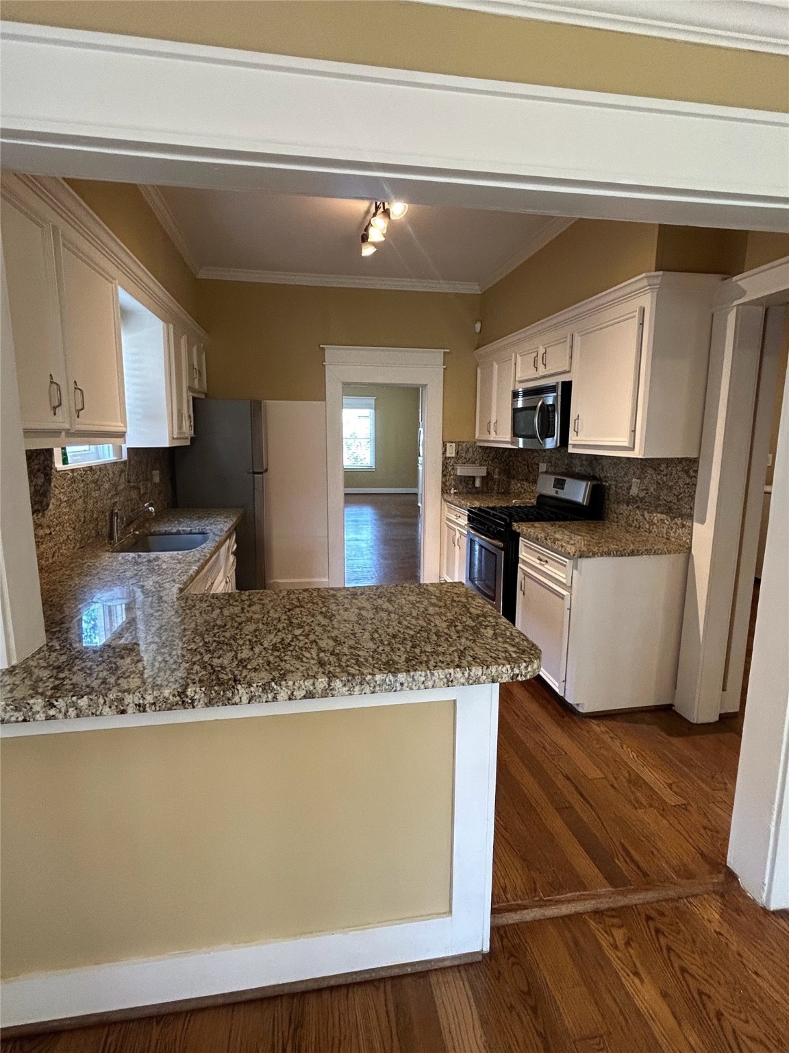209 Walton Street Houston, TX 77009 - Photo 11 of 24 a kitchen with stainless steel appliances granite countertop a sink stove and wooden cabinets