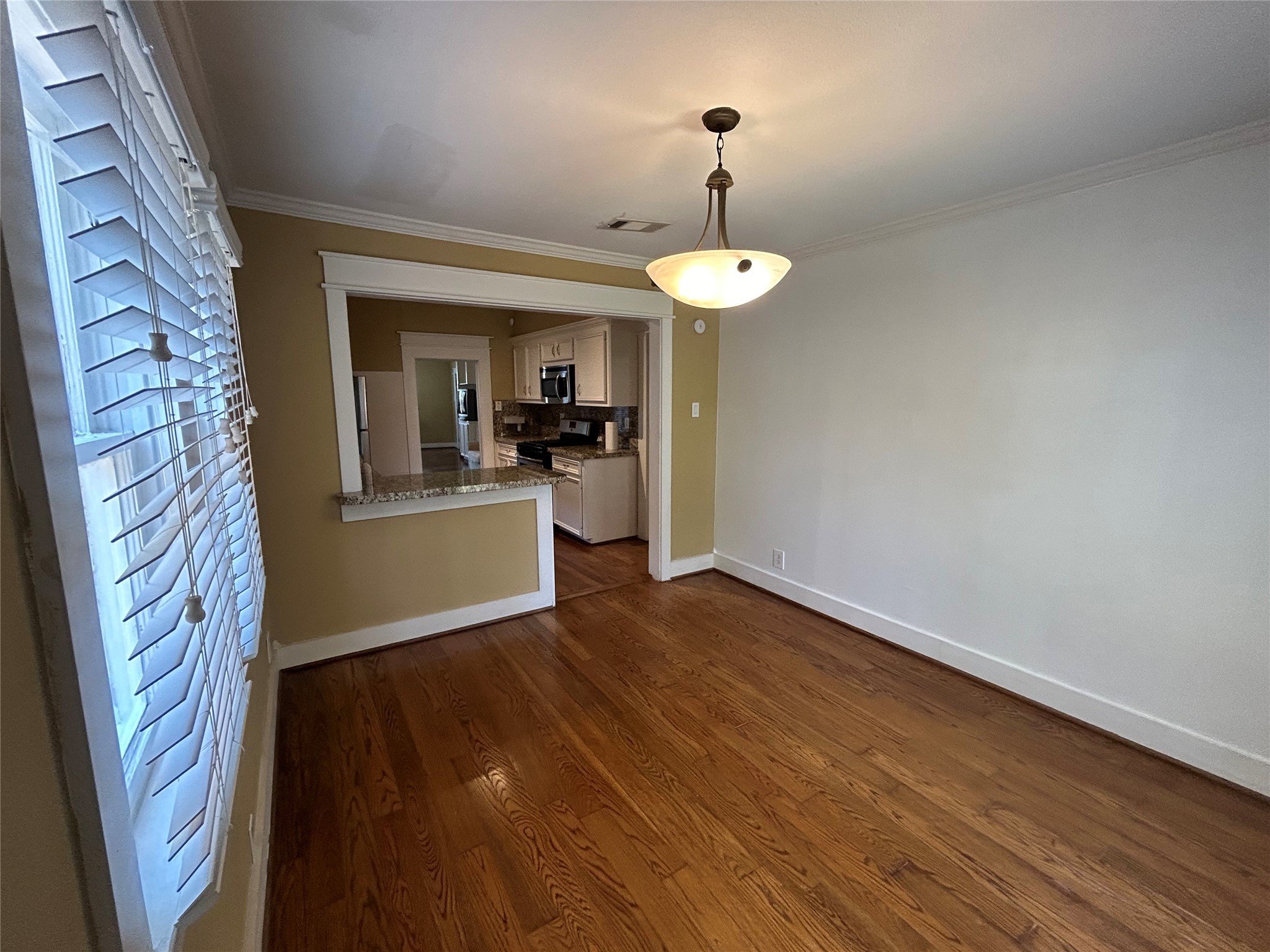 209 Walton Street Houston, TX 77009 - Photo 13 of 24 a view of a kitchen with a sink wooden floor a fireplace and a window
